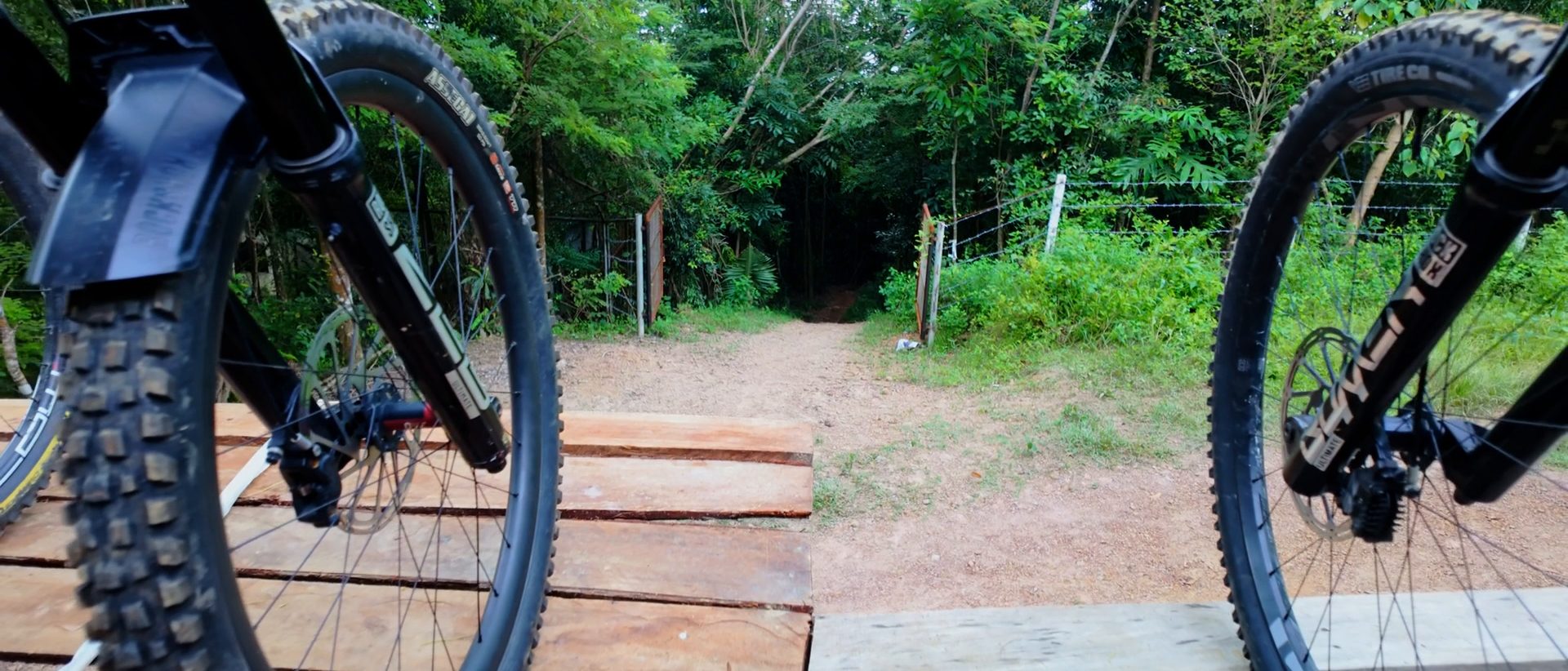 Mountain bike wheels rolling over a wooden trail feature